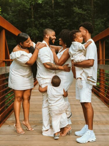 man in white dress shirt carrying baby in white dress